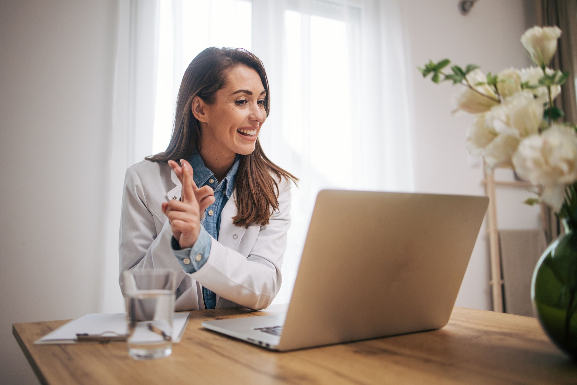 Female doctor sitting in home office and using laptop computer. Female doctor sitting in home office and using laptop computer.